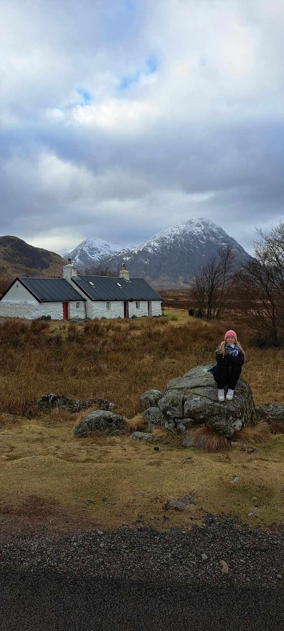Scottish Highland landscape with white cottage and snow-capped mountains